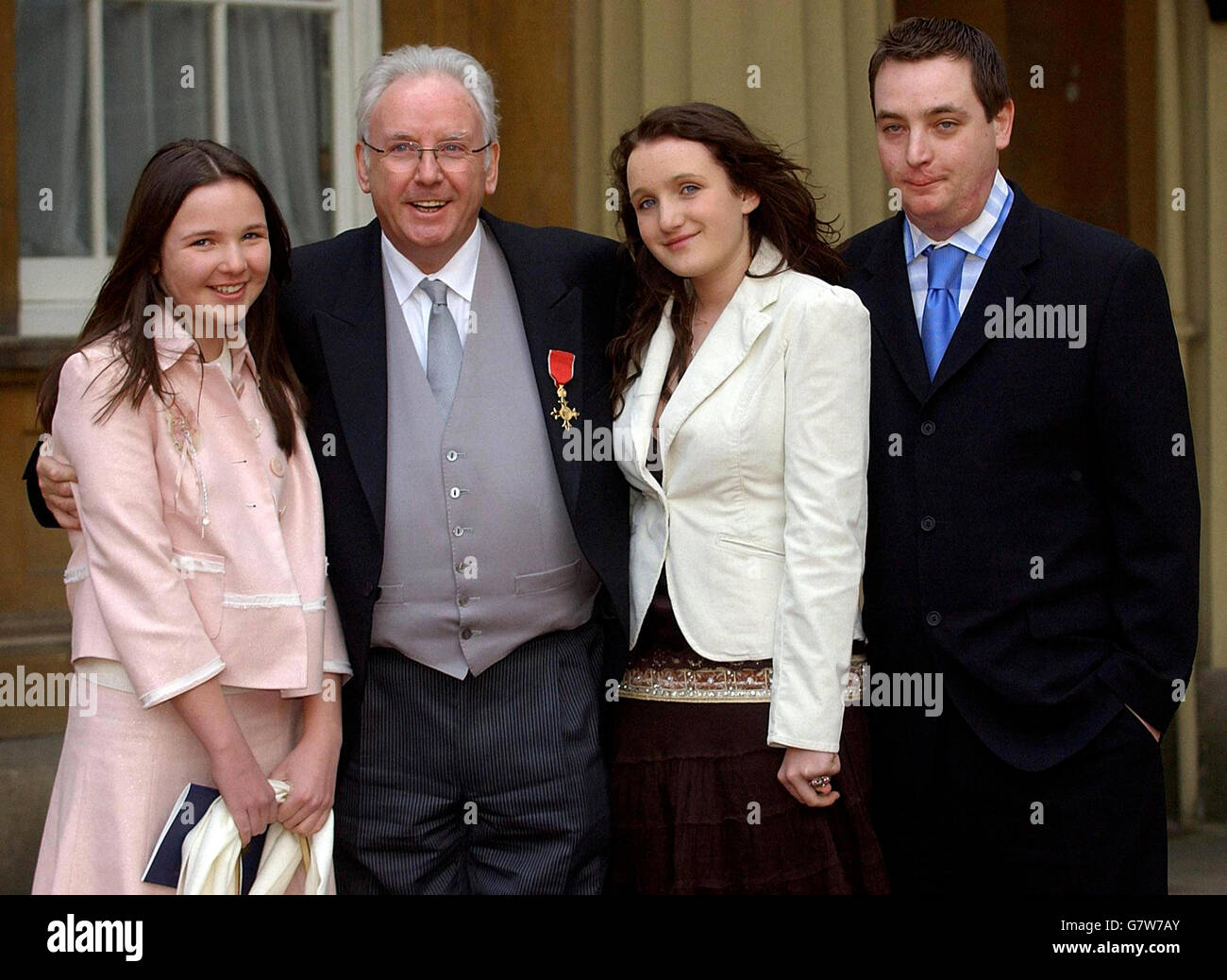 Pop impresario Pete Waterman (secondo da sinistra) con i suoi figli (da sinistra) Charlie, 13, Tonie, 15 e Peter, 23 dopo aver raccolto un OBE per i servizi alla musica dalla Regina Elisabetta II. Foto Stock