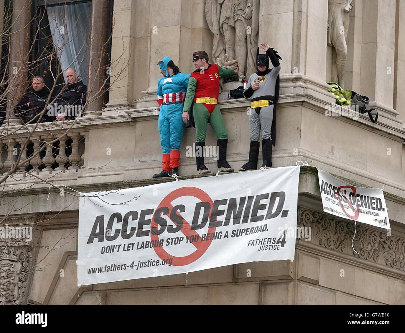 Tre membri della giustizia dei Padri 4 vestiti come supereroi Capitano America, Batman e Robin su una sporgenza del Ministero degli Esteri, sopra l'incrocio di Whitehall e Downing Street. Foto Stock