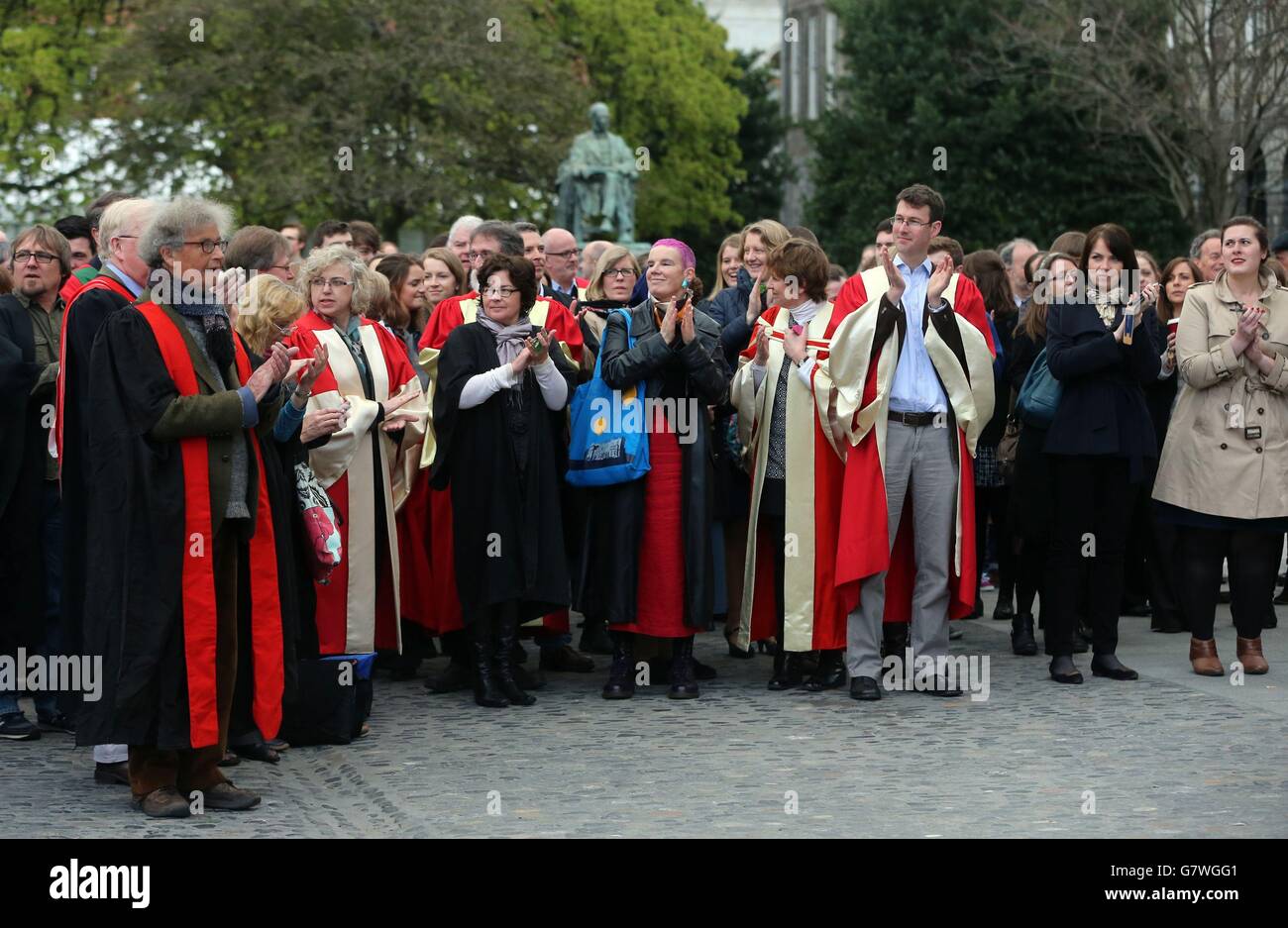 Studenti e docenti applaudono durante l'annuncio dei nuovi studiosi e Fellow in Front Square al Trinity College di Dublino. Foto Stock