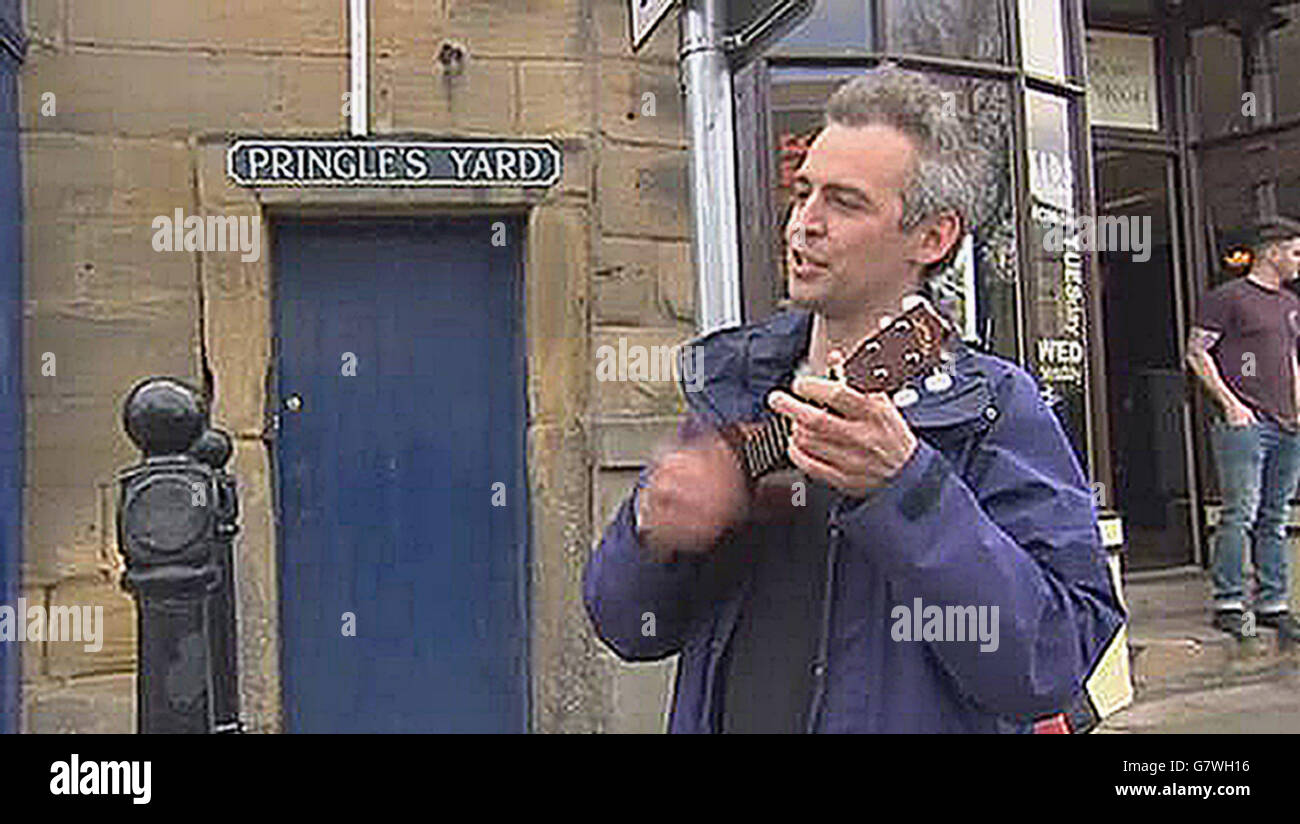 Screen grab taken from PA Video di un uomo con un ukulele che serenò il primo ministro David Cameron con 'f*** off back to Eton' durante una visita ad Alnwick. Foto Stock