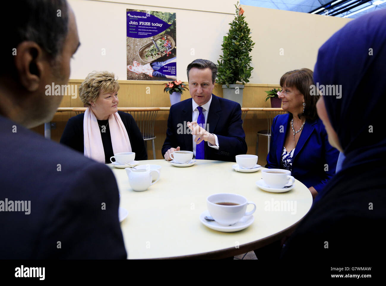 Il primo ministro David Cameron e il suo attivista per le pensioni Ros Altmann (destra), che diventerà un ministro se i conservatori saranno rieletti, parlano con persone che si avvicinano all'età pensionabile al Melbicks Garden Centre di Birmingham, durante la campagna elettorale generale. Foto Stock
