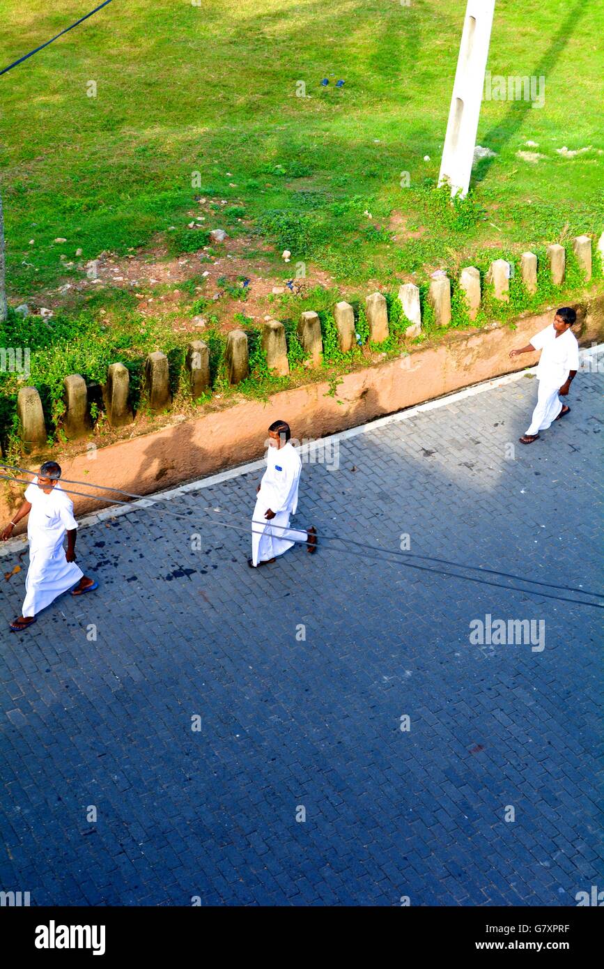 Tre uomini in bianche vesti a camminare su una strada a Galle Sri Lanka Foto Stock