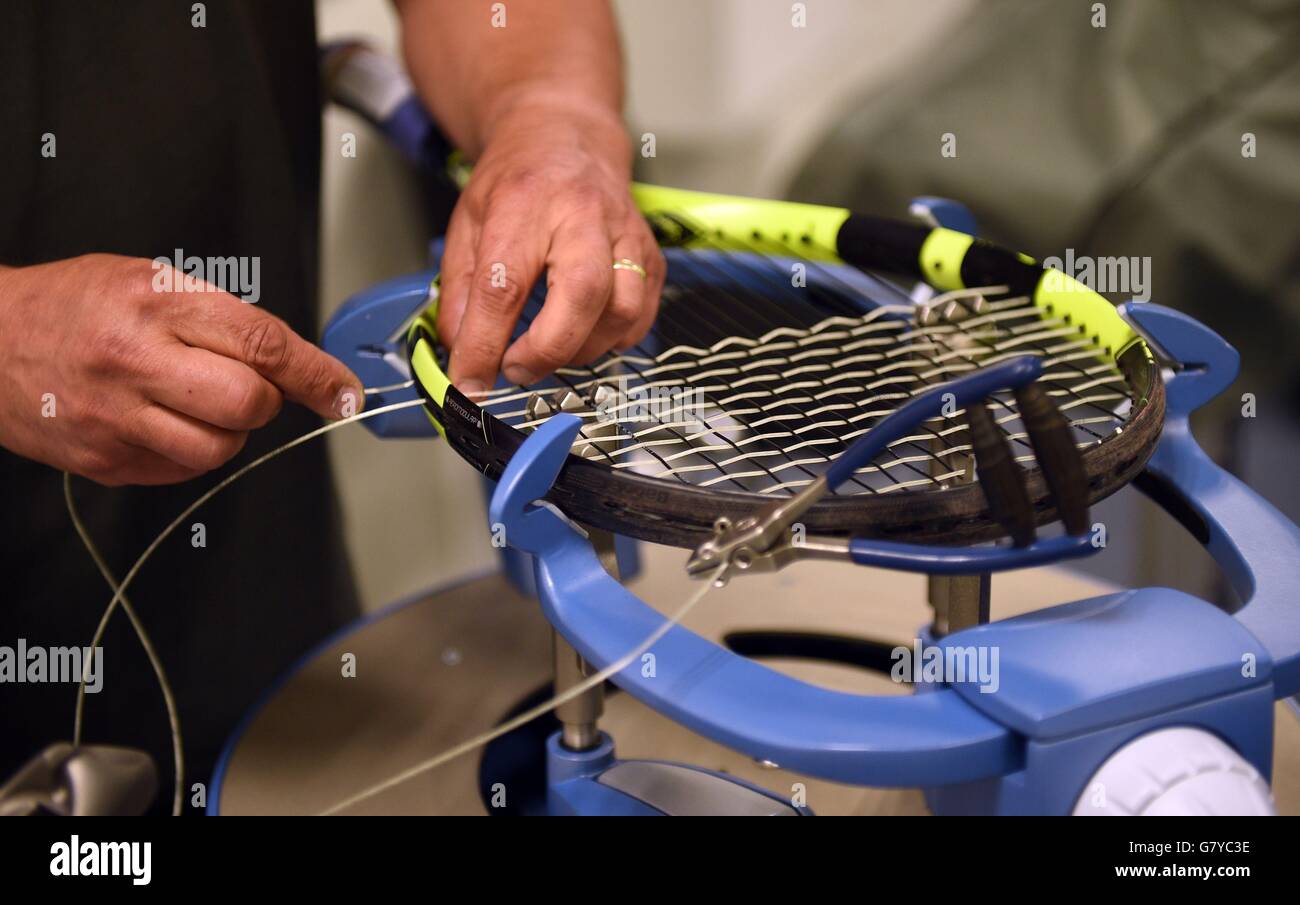 Rob Maessen di Apollo Leisure ri-stringhe che un giocatore di racket prima dell'inizio del 2016 campionati di Wimbledon. Foto Stock