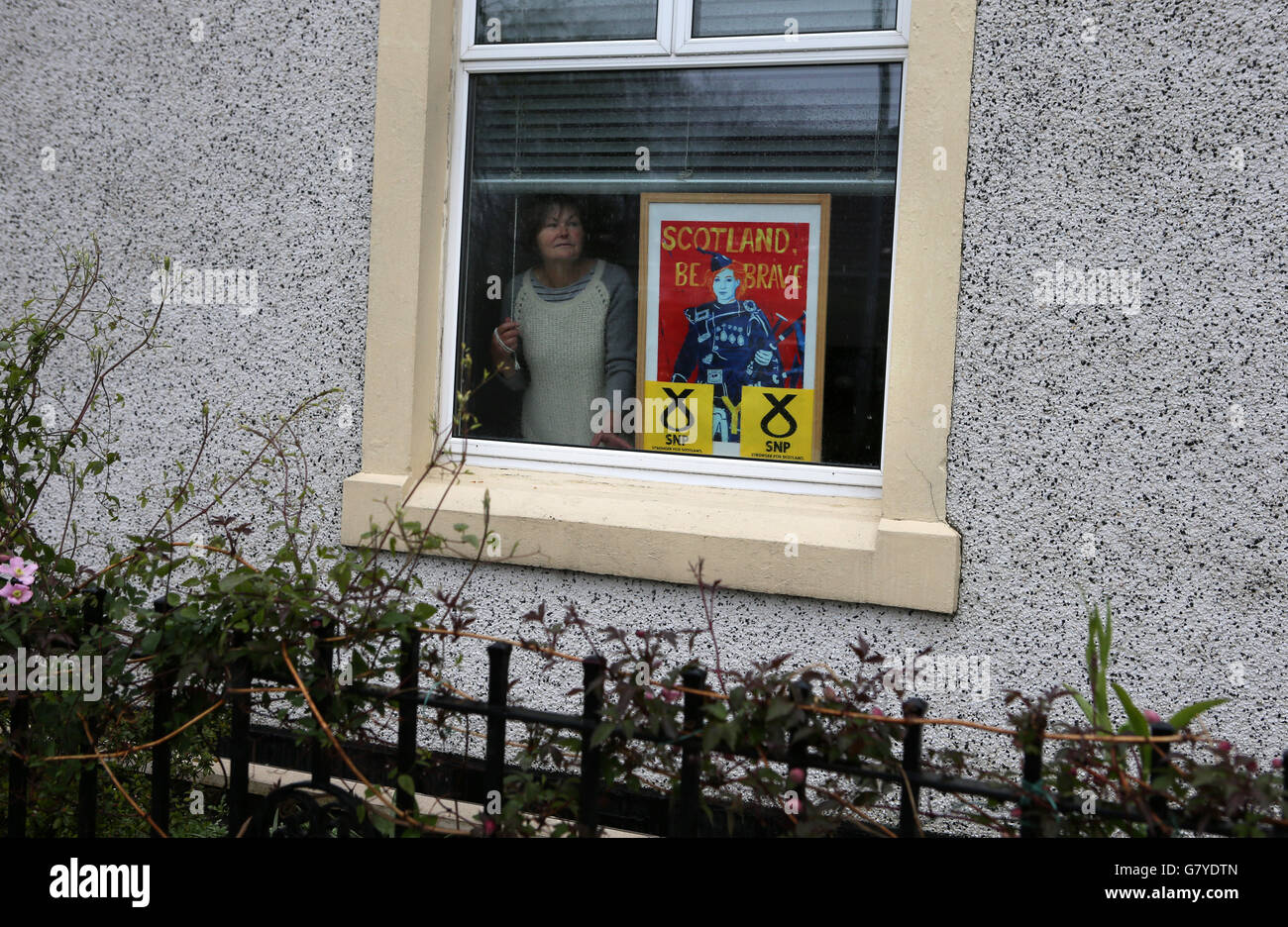 La sostenitrice della SNP Joan MacMillan con il suo segno nella finestra della sua casa a Tillicoultry, Clackmannanshire, Scozia. Foto Stock