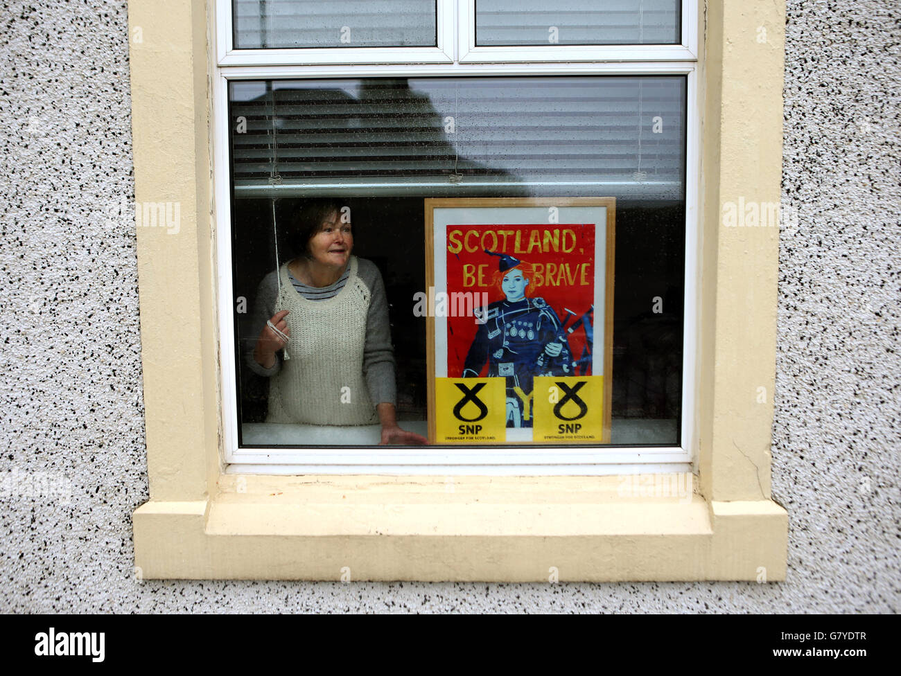 La sostenitrice della SNP Joan MacMillan con il suo segno nella finestra della sua casa a Tillicoultry, Clackmannanshire, Scozia. Foto Stock