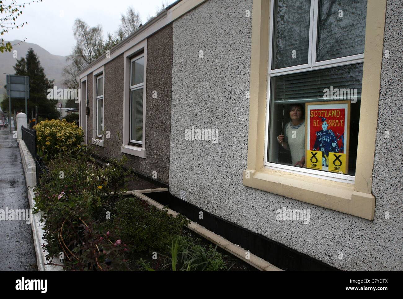 La sostenitrice della SNP Joan MacMillan con il suo segno nella finestra della sua casa a Tillicoultry, Clackmannanshire, Scozia. Foto Stock