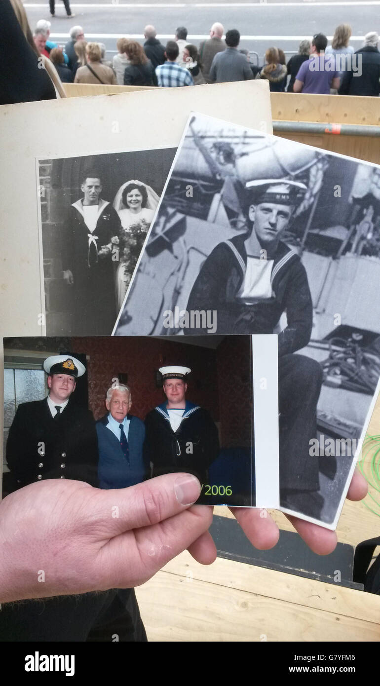 Il funzionario della Royal Navy Lieutenant Morgan McDonald conserva fotografie del nonno Sinclair 'Mick' West, tra cui (fotografia anteriore sinistra - destra) lui stesso, il signor West e Douglas Mason mentre partecipa al 70° anniversario delle commemorazioni del VE Day al Cenotaph di Whitehall, Londra. Foto Stock