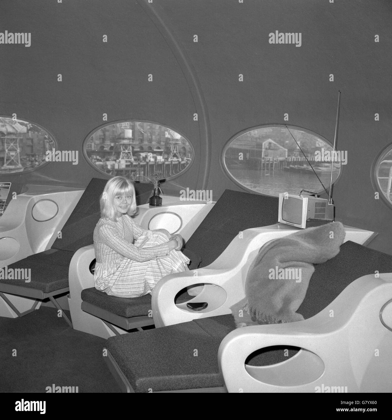Con una vista laterale sul Tamigi attraverso le finestre ovali, Hedi Lindblom di 23 anni, si arriccia nel comfort moderno del 'futuro' - una casa a forma di disco con l'aspetto esterno di un piattino volante. Descritta come la casa per il tempo libero di oggi e di domani, è in vista in Finnfocus 68, una mostra galleggiante organizzata da giovani studenti finlandesi di economia come parte del loro paese di esportazione di guida. Foto Stock