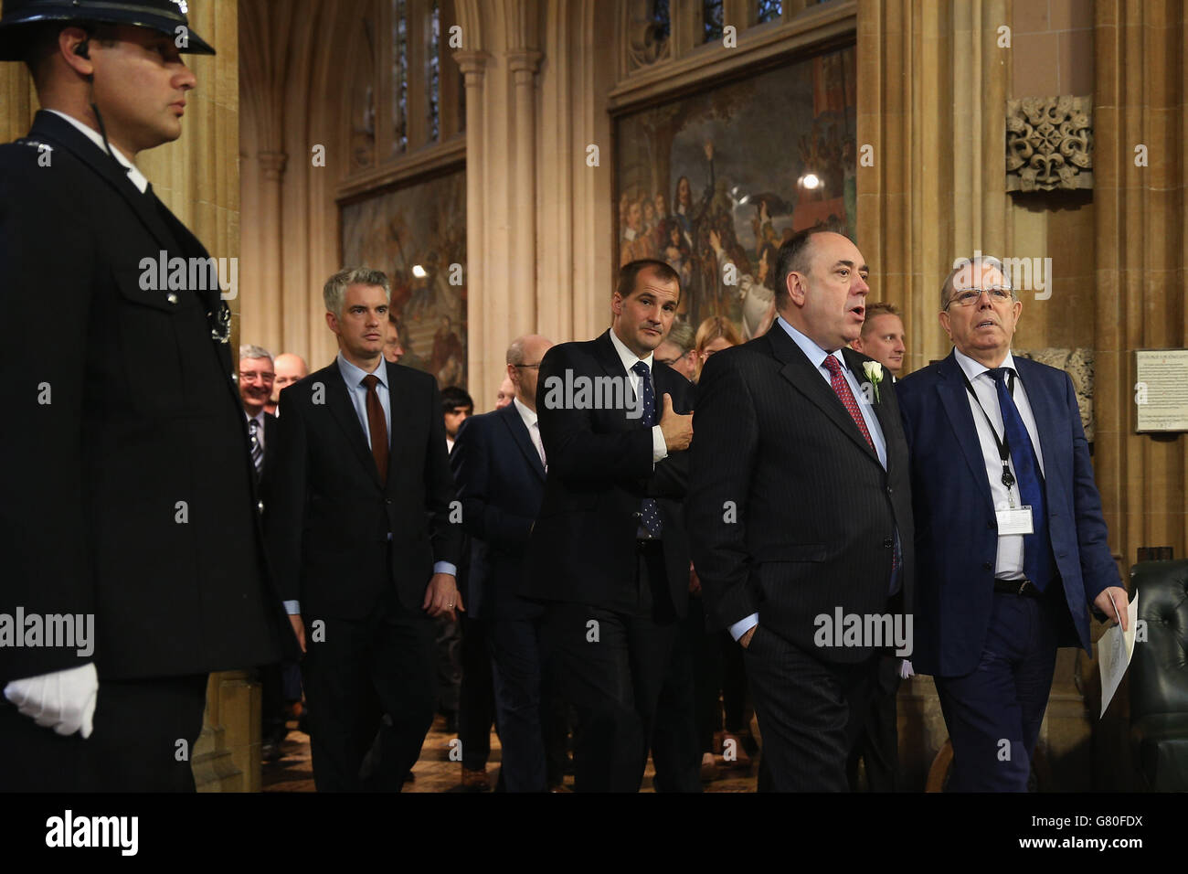 L'ex primo ministro scozzese e il neoeletto membro del parlamento, Alex Salmond (davanti a sinistra), lasciano la lobby centrale dopo l'apertura del Parlamento presso il Palazzo di Westminster a Londra. Foto Stock