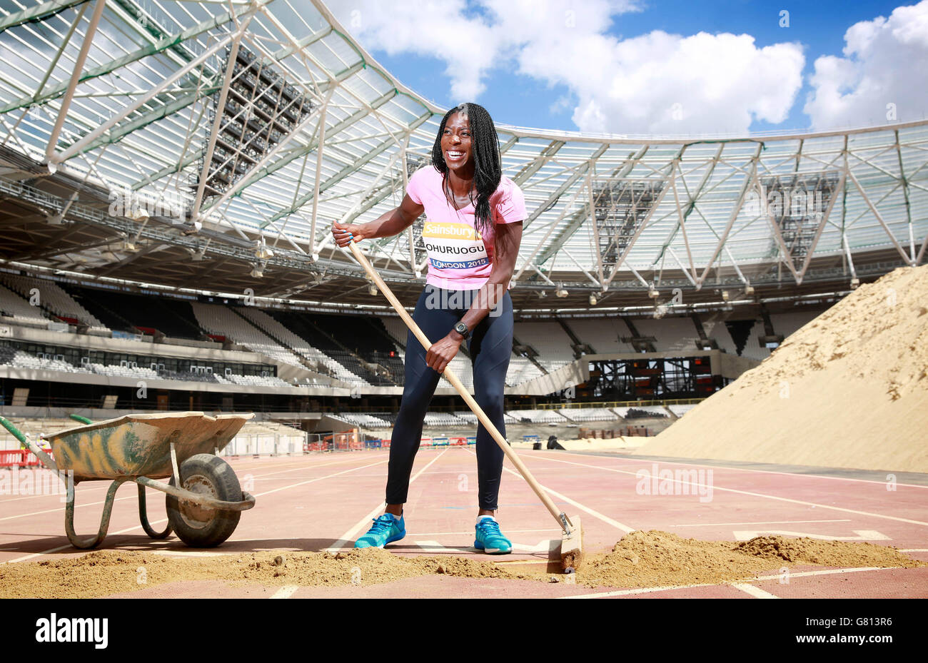 Christine Ohuruogu, campione del mondo di 400m, spazza via lo strato protettivo finale di terreno dal traguardo nell'ex Stadio Olimpico per la prima volta dall'inizio dei lavori di trasformazione 18 mesi fa, al Queen Elizabeth Olympic Park, in vista dei Giochi d'anniversario di Sainsbury dal 24 al 26 luglio. Foto Stock