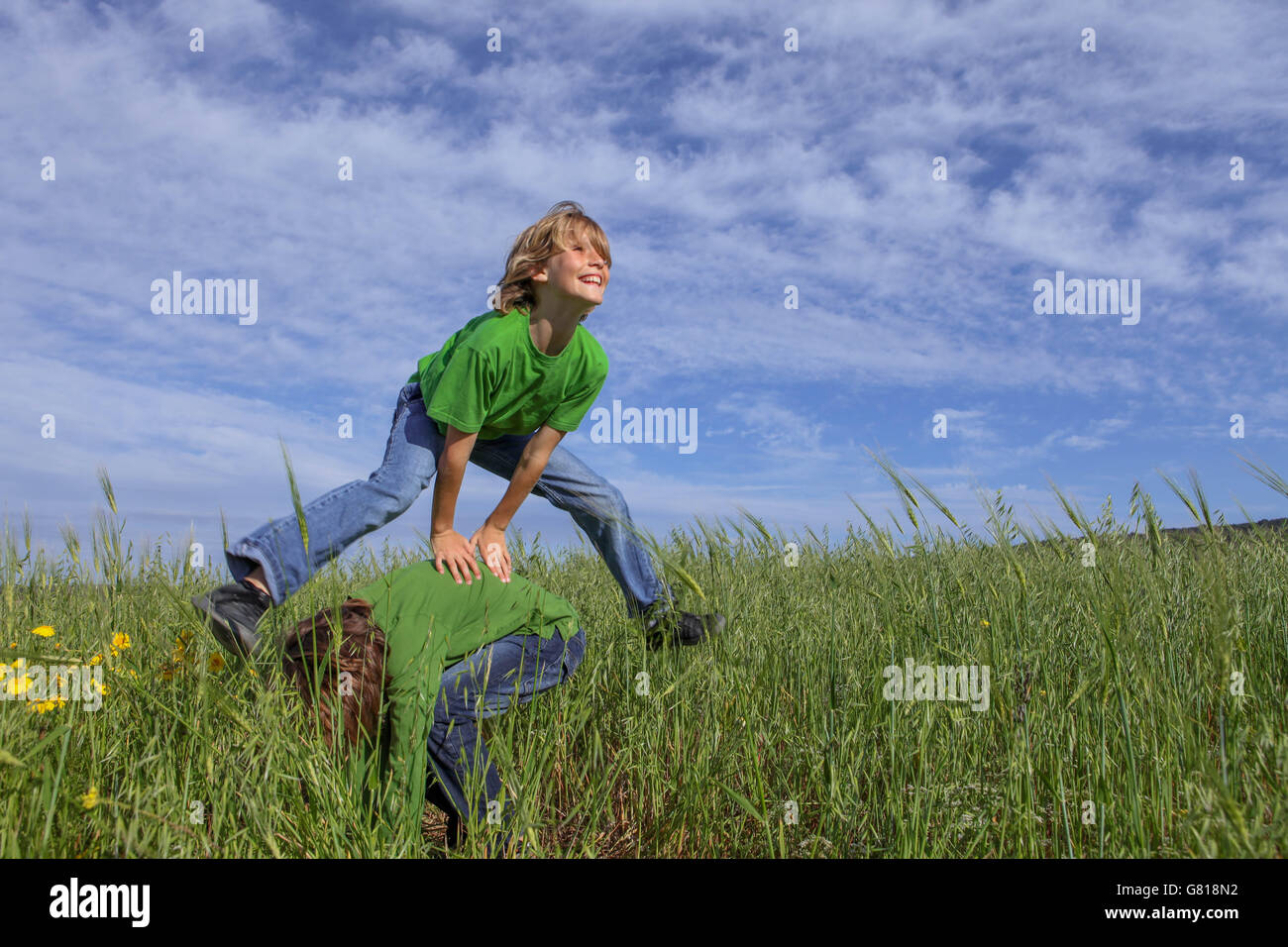 Felici i bambini sani gioca cavallina di estate gioco Foto Stock