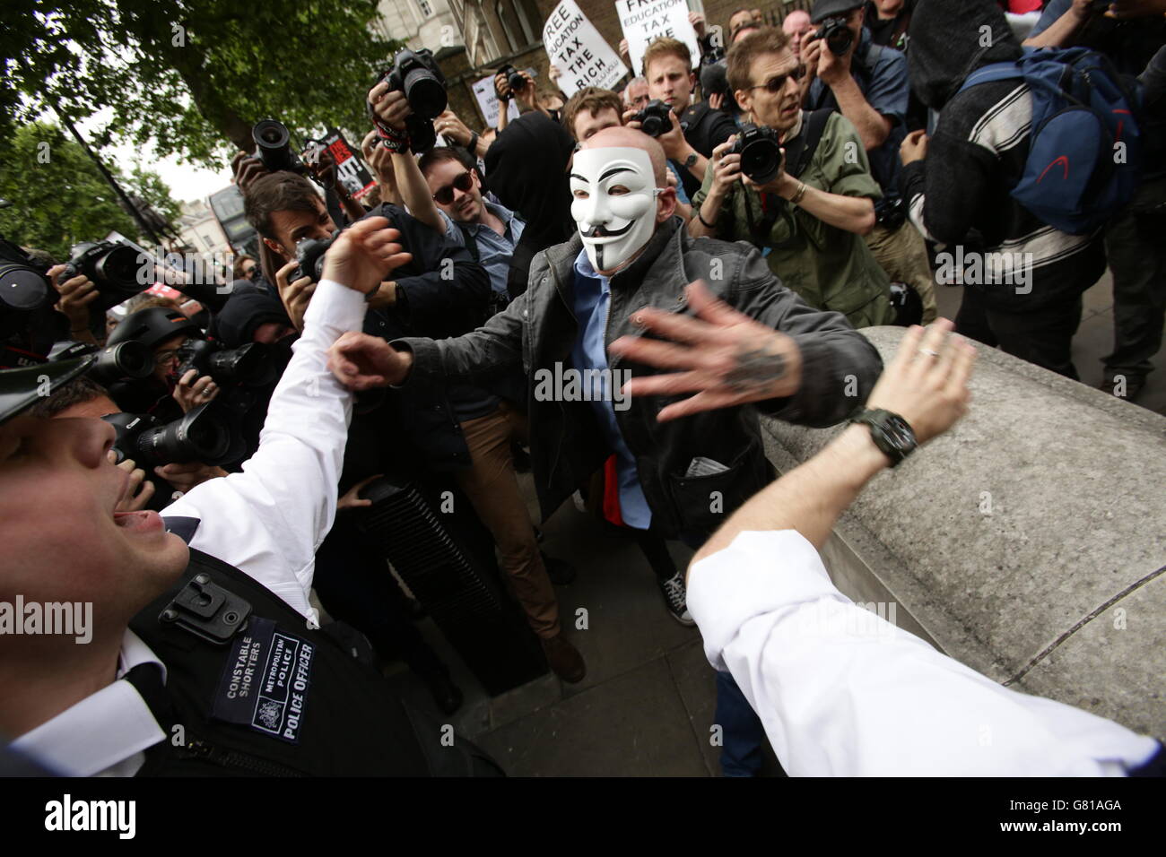 La polizia si trova a contatto con un uomo, durante una protesta anti-austerità a Whitehall, nel centro di Londra, mentre i manifestanti si oppongono alle misure indicate nel discorso della Regina, in seguito all'apertura del Parlamento da parte dello Stato. Foto Stock