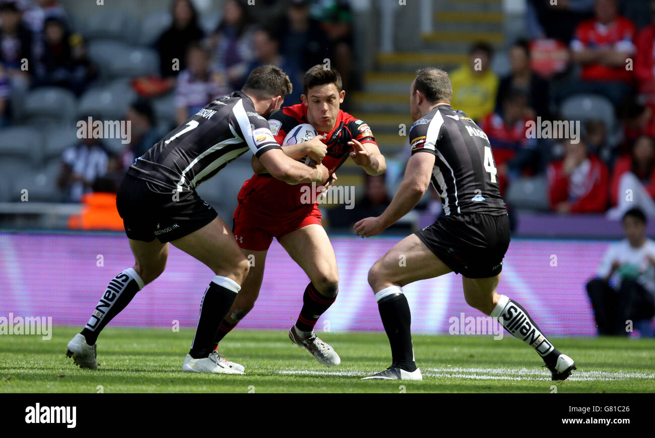 I diavoli rossi di Salford Niall Evalds sono tenuti da Widnes Vikings Stefan Marsh e Joe Mellor (a sinistra) durante la partita del Magic Weekend al St James' Park, Newcastle. Foto Stock