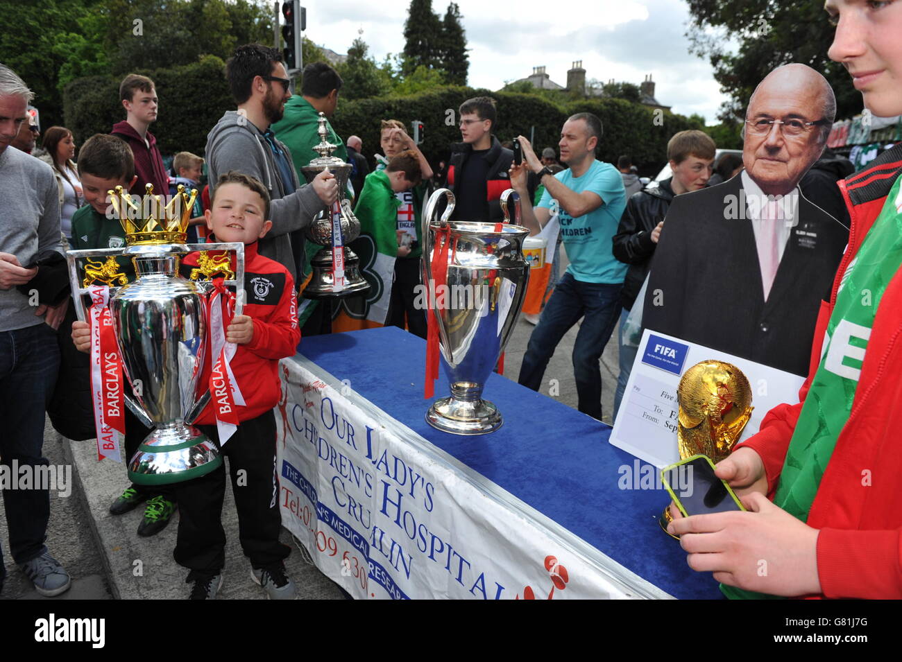 I tifosi di calcio si levano in piedi con un taglio di cartone di Sepp Blatter in vista della partita di calcio internazionale amichevole tra la Repubblica d'Irlanda e l'Inghilterra allo stadio Aviva di Dublino. Foto Stock