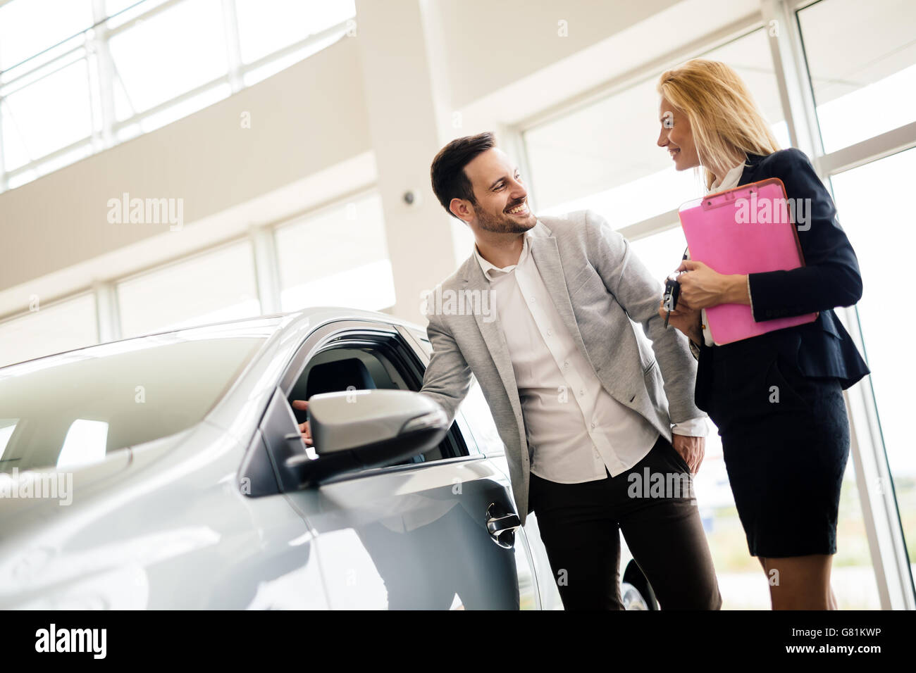 Clienti in cerca di una vettura presso la concessionaria e la personalizzazione di veicolo Foto Stock