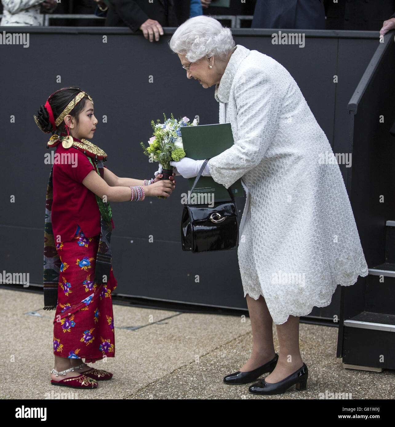 La regina Elisabetta II riceve un bouquet di fiori da sei anni Swechya Joshi, figlia di un gurkha al servizio alla conclusione del Gurkha 200 pageant al Royal Hospital Chelsea, Londra. Foto Stock