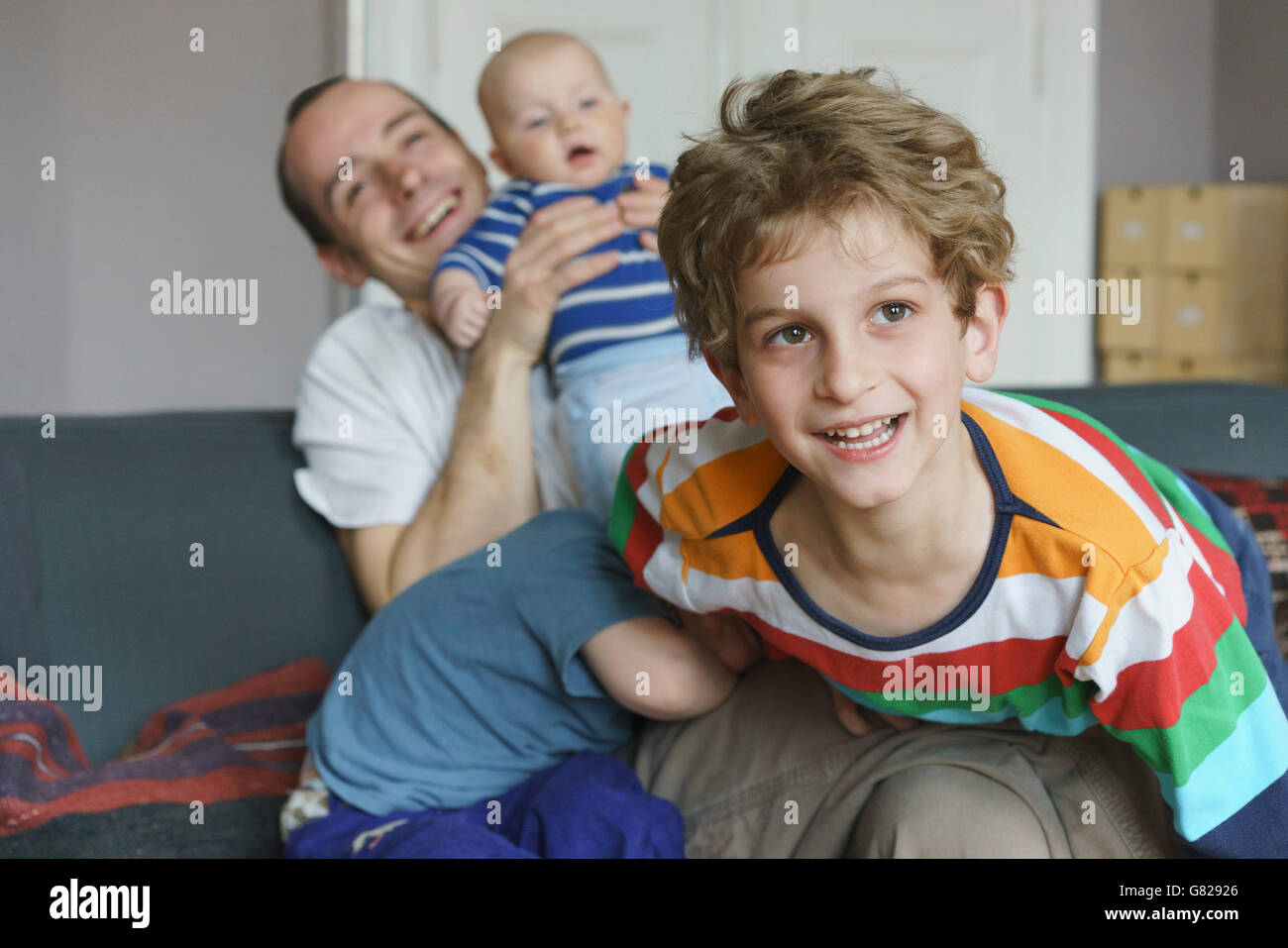 La famiglia felice giocando sul divano di casa Foto Stock