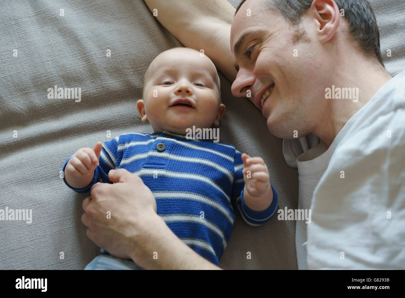 Elevato angolo di visione del padre giaceva con figlio sul letto di casa Foto Stock