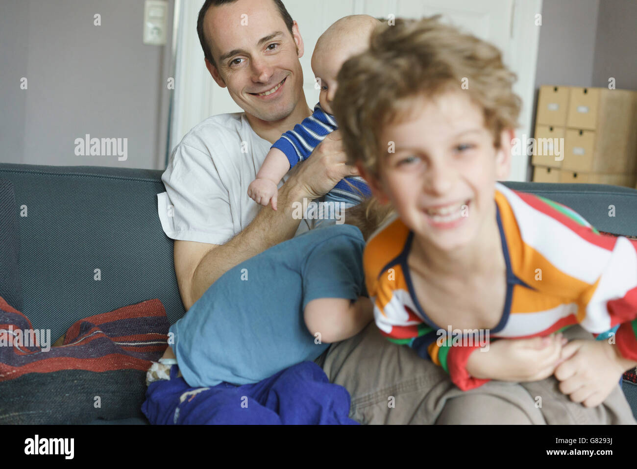 La famiglia felice giocando sul divano di casa Foto Stock