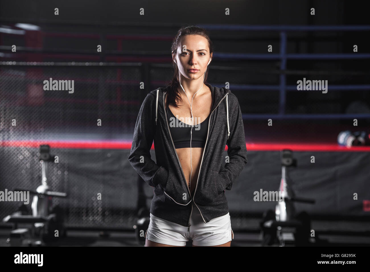 Atleta femminile con le mani nelle tasche in piedi alla palestra Foto Stock