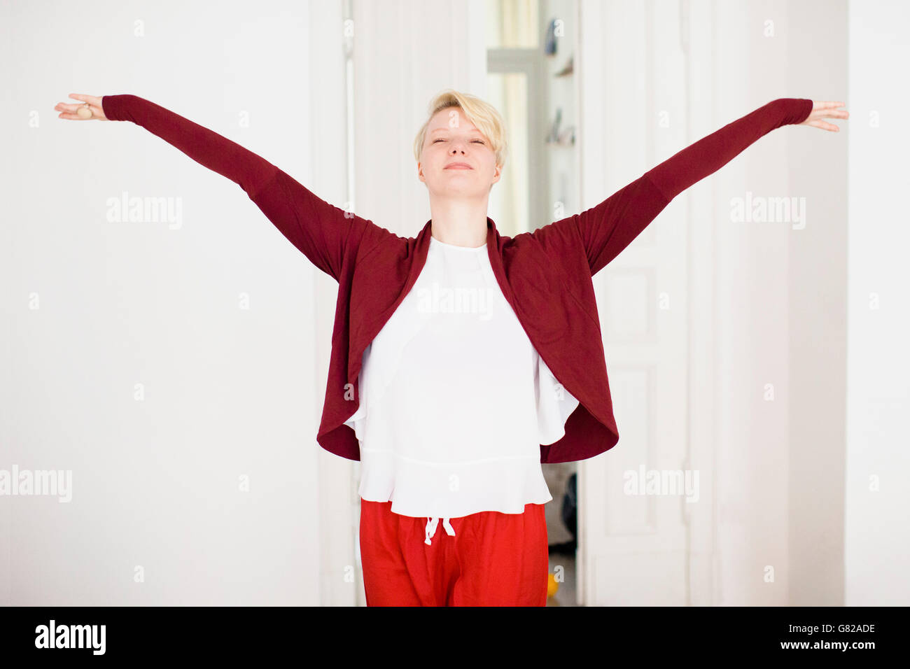 Rilassata metà donna adulta con le braccia aperte a casa Foto Stock