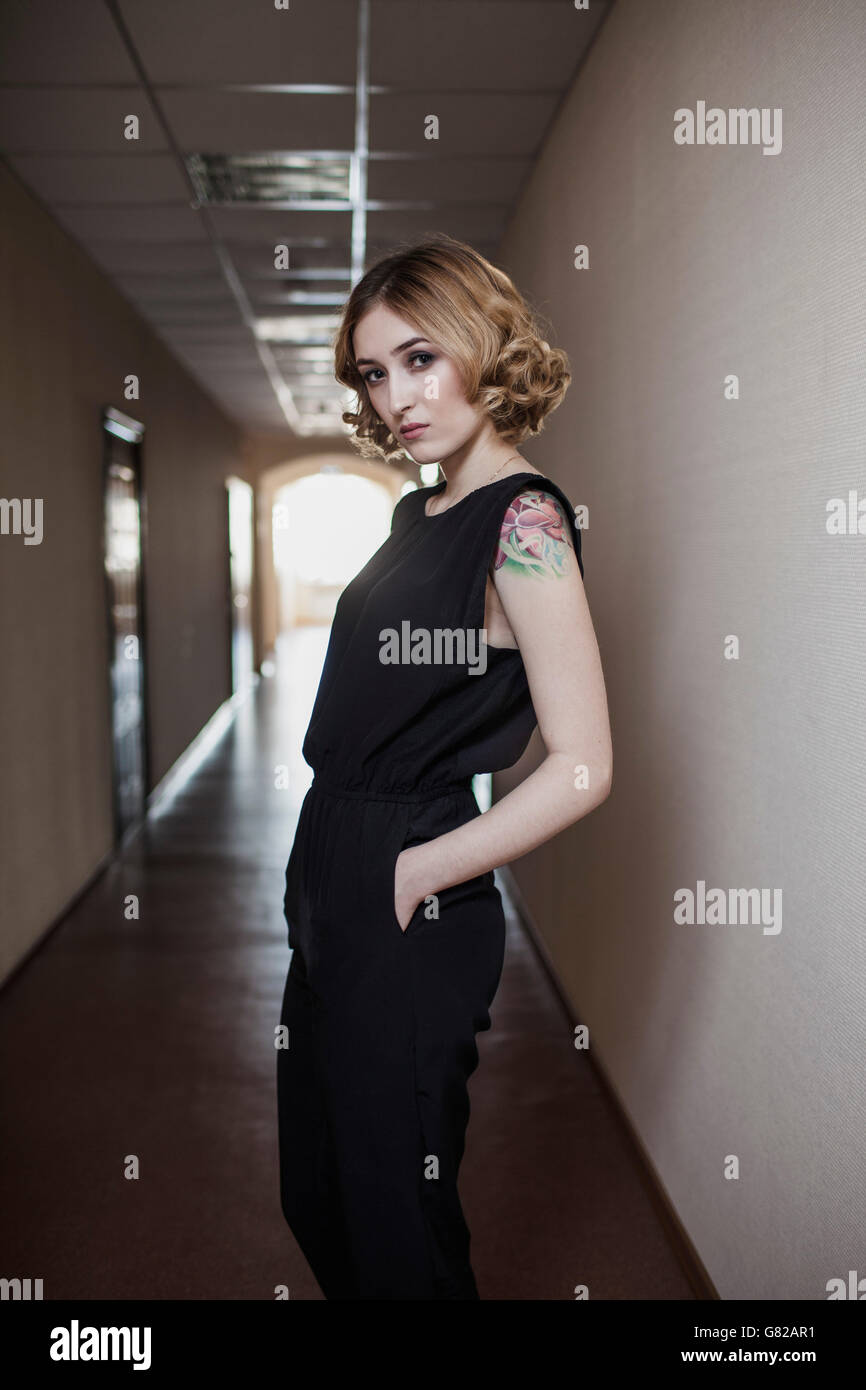 Ritratto di giovane e bella donna in piedi nel corridoio Foto Stock