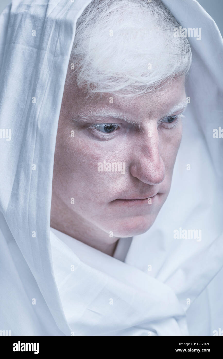 Close-up di giovane uomo albino avvolto in tessuto bianco Foto Stock