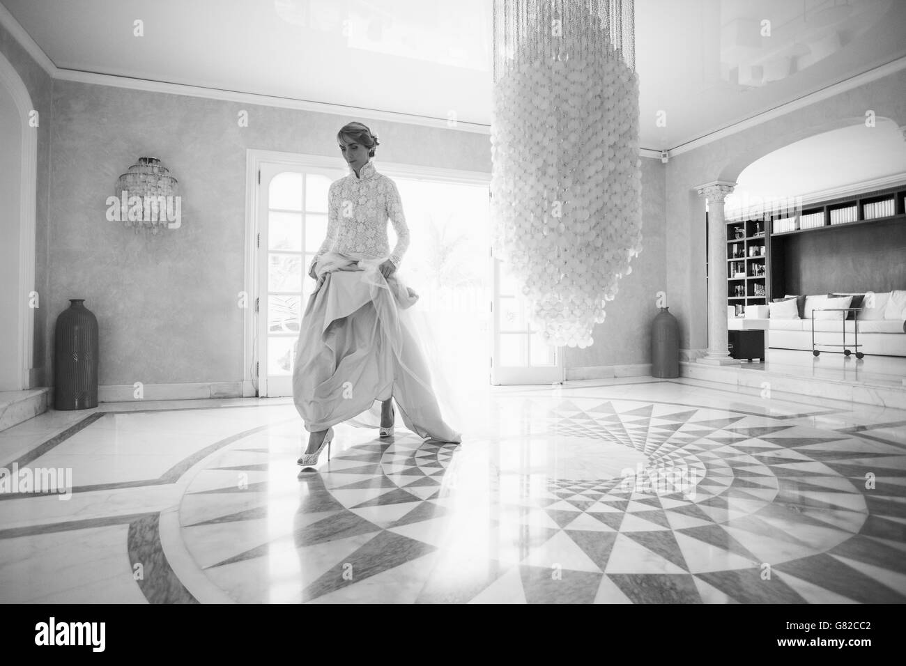 Per tutta la lunghezza della metà adulto sposa camminando sul pavimento a motivi geometrici Foto Stock
