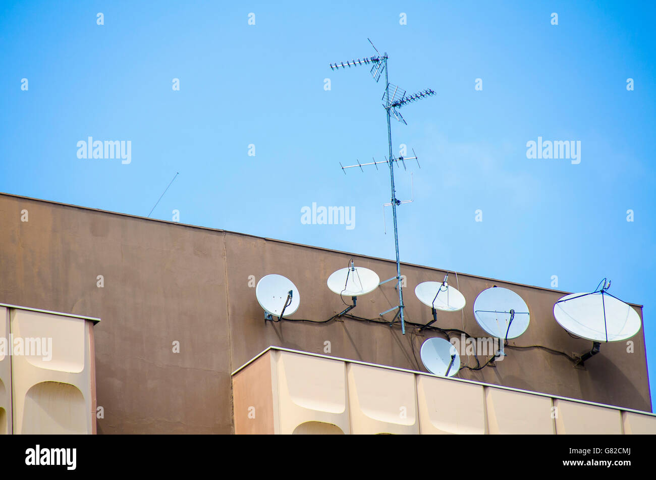 Basso angolo vista di antenne e parabole satellitari su edificio contro sky Foto Stock
