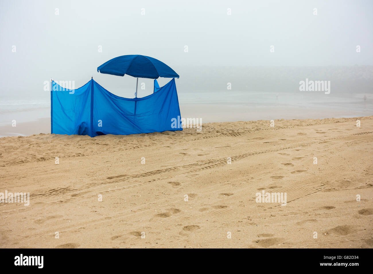 Tenda blu e ombrellone in spiaggia contro il cielo durante la nebbia meteo  Foto stock - Alamy