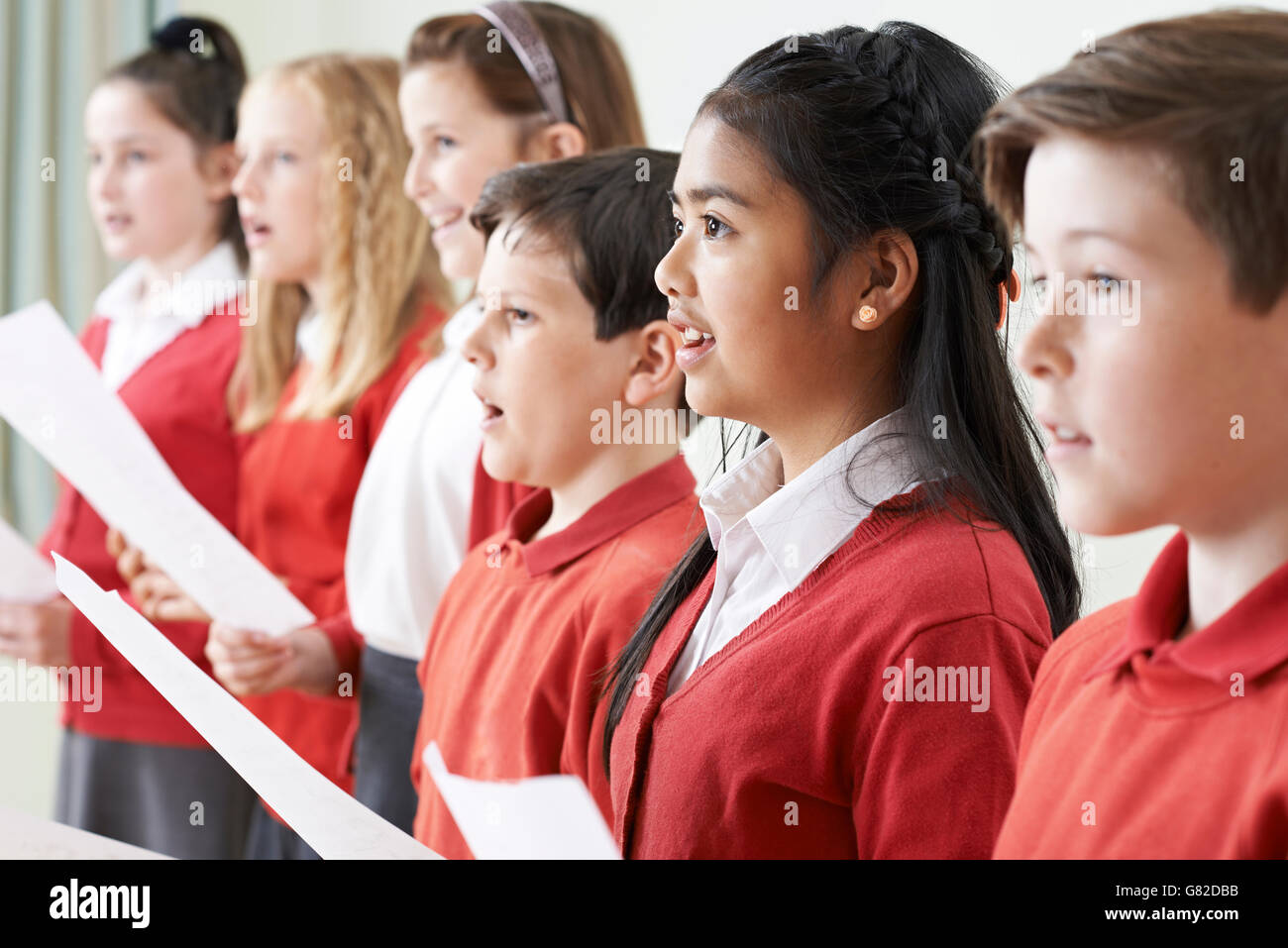 Gruppo di bambini a cantare in coro scolastico Foto Stock