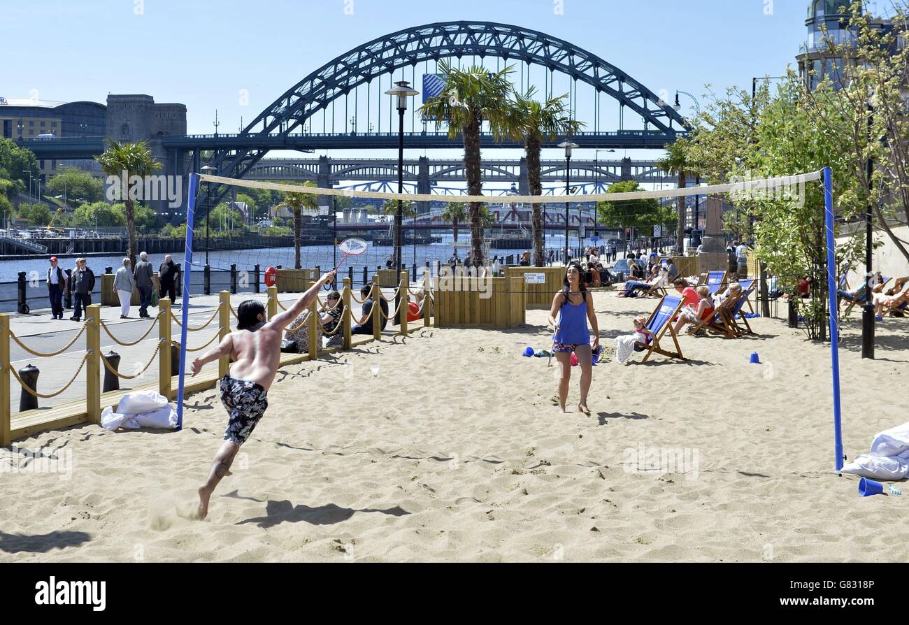 Nisha Poontah (l), 27, Nasir Khan, 29, e la figlia Maya, 3, sulla spiaggia artificiale di Newcastle Quayside, come un grave avvertimento meteo è stato emesso per temporali il Venerdì, che potrebbe essere il giorno più caldo dell'anno finora. Foto Stock