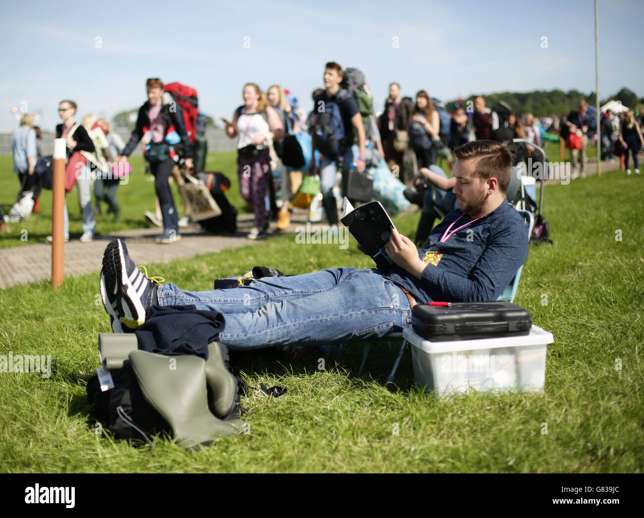 Glastonbury Festival 2015 - preparazione. Un festeggiatore che si rilassa al Festival di Glastonbury presso la Worthy Farm nel Somerset. Foto Stock