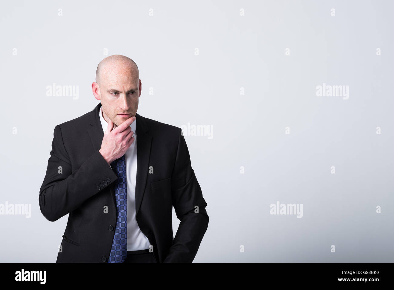 Risoluzione dei problemi, uomo d'affari calvo con un vestito e una cravatta dall'aspetto premuroso con spazio di copia a destra dell'immagine Foto Stock