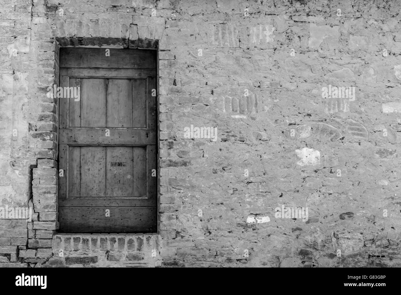 Rustico porta di legno in bianco e nero in muratura casuale - sfondo Foto Stock