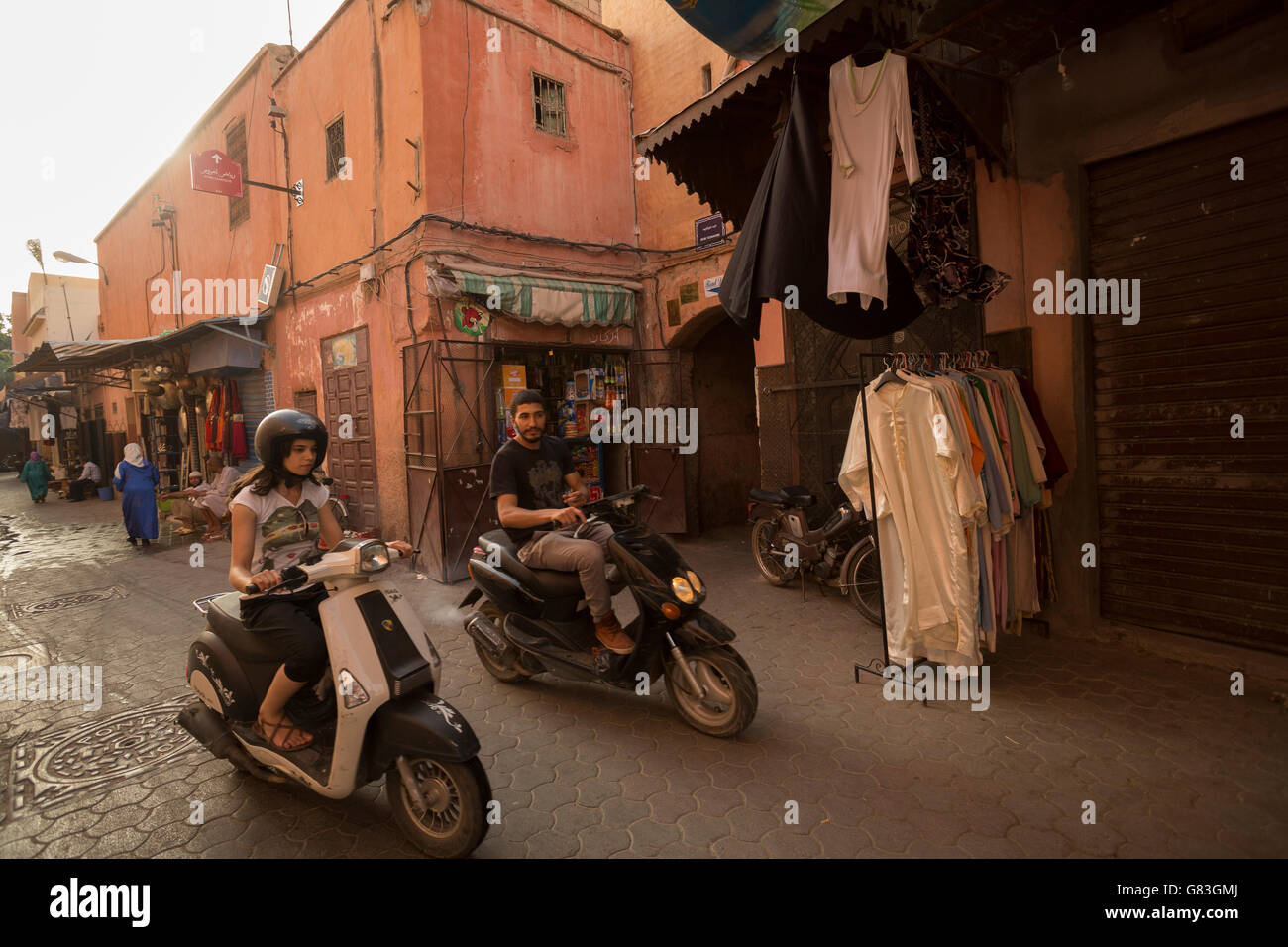 I residenti locali e turisti dash attraverso le strette strade della Medina di Marrakesh, Marocco. Foto Stock