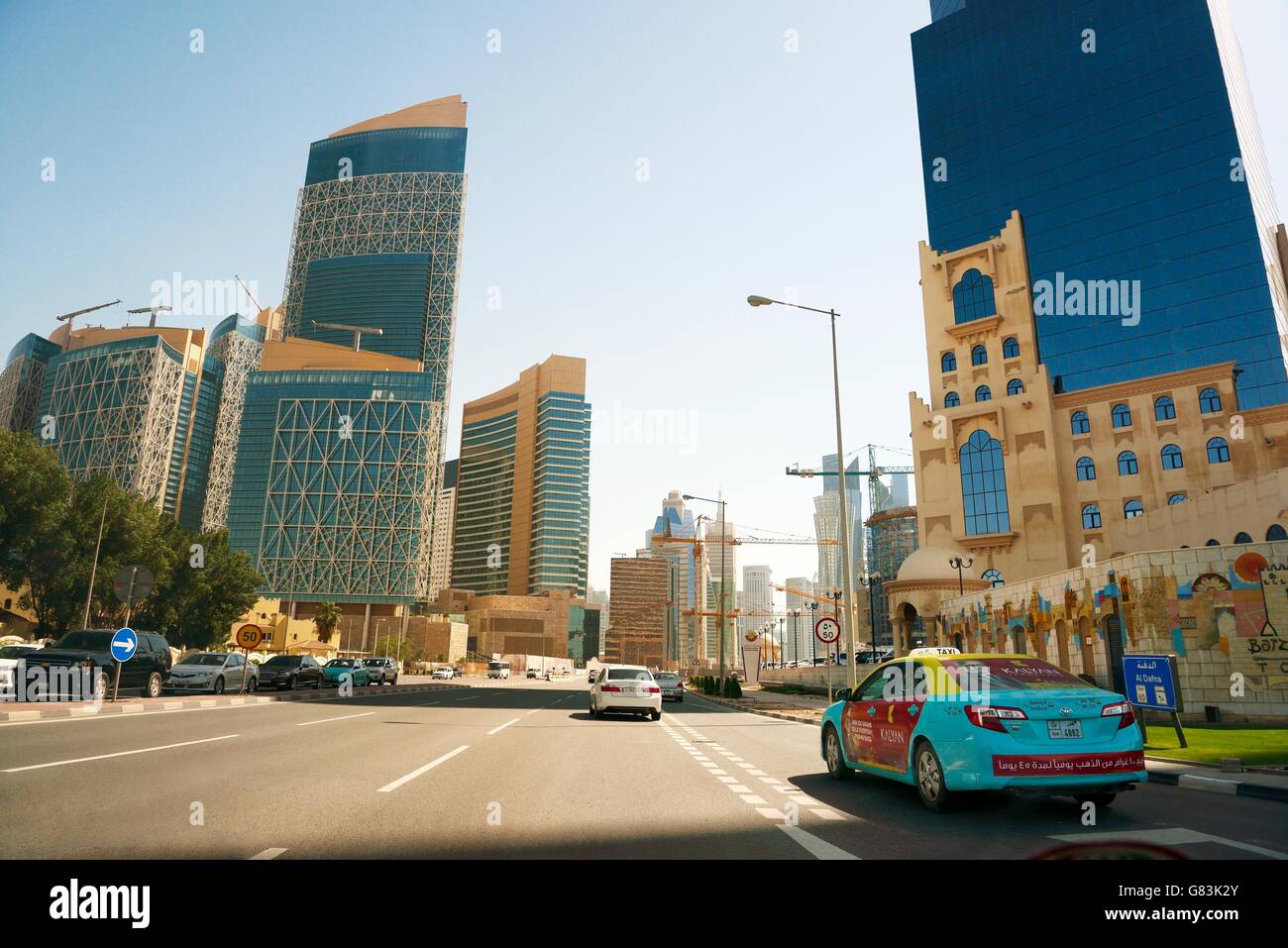 Si entra nel centro di Doha, in Qatar, il Majlis Al Taawon Street. Barzan torre sulla destra Qatar Petroleum District complesso sulla sinistra Foto Stock
