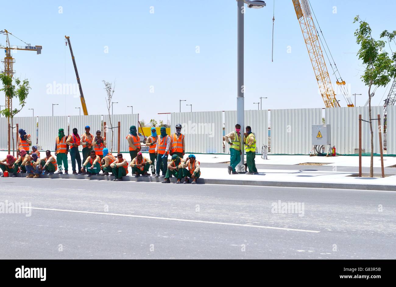 Marina District della nuova città in rapido sviluppo di Lusail, Qatar. I lavoratori immigrati dei cantieri edili aspettano il trasporto Foto Stock