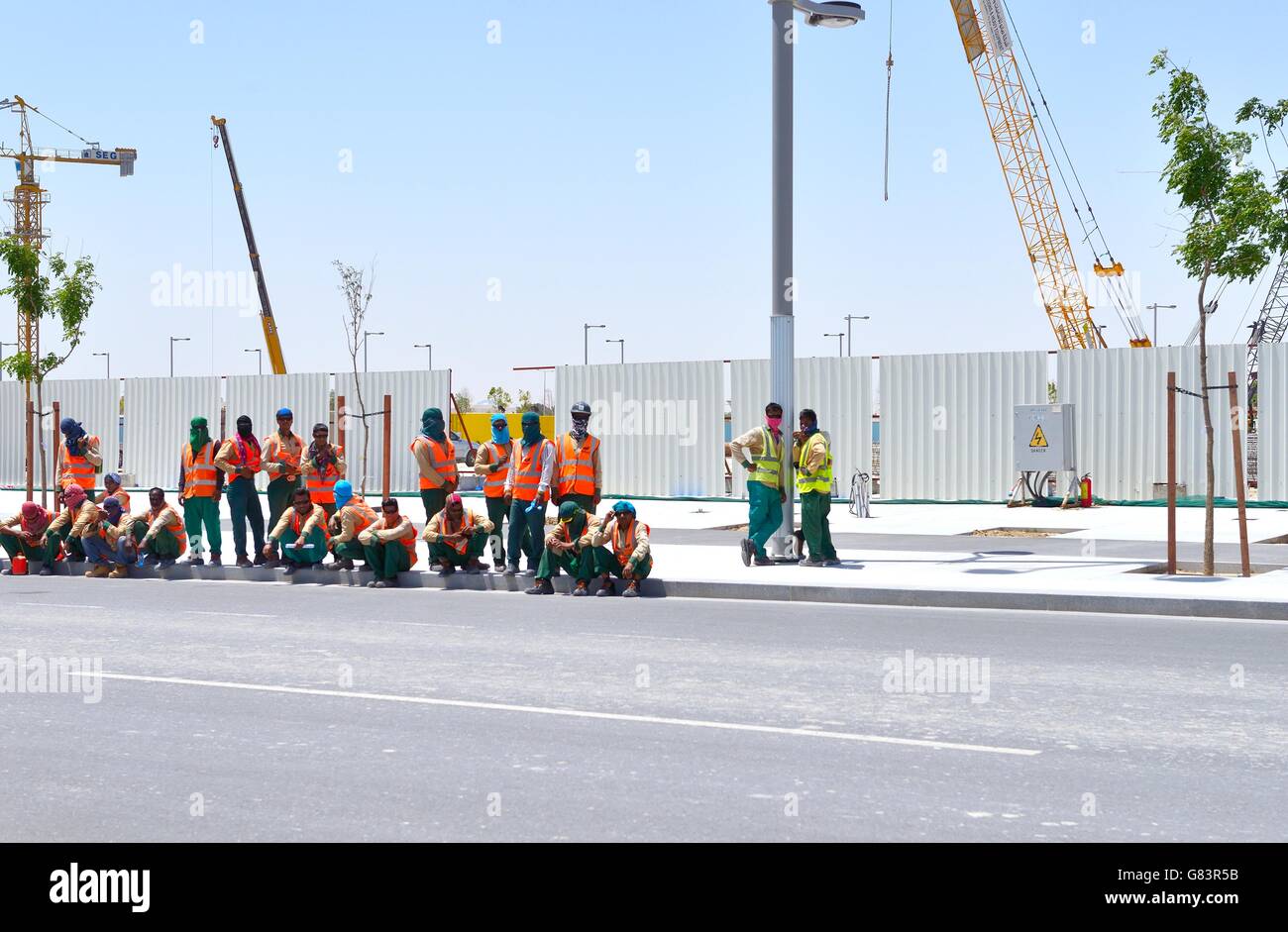 Marina District di sviluppare rapidamente nuove città di lusail, Qatar. immigrato cantiere lavoratori edili di attendere per il trasporto Foto Stock
