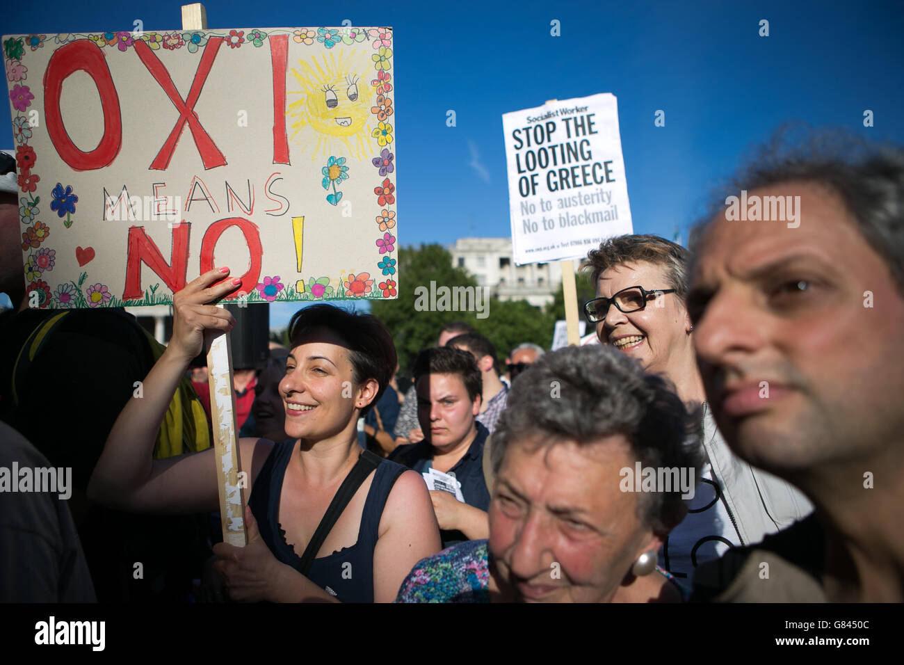 I manifestanti che detengono cartelli prendono parte a una protesta contro la Banca Centrale europea, a Trafalgar Square, Londra, per i rimborsi del debito greco. Foto Stock