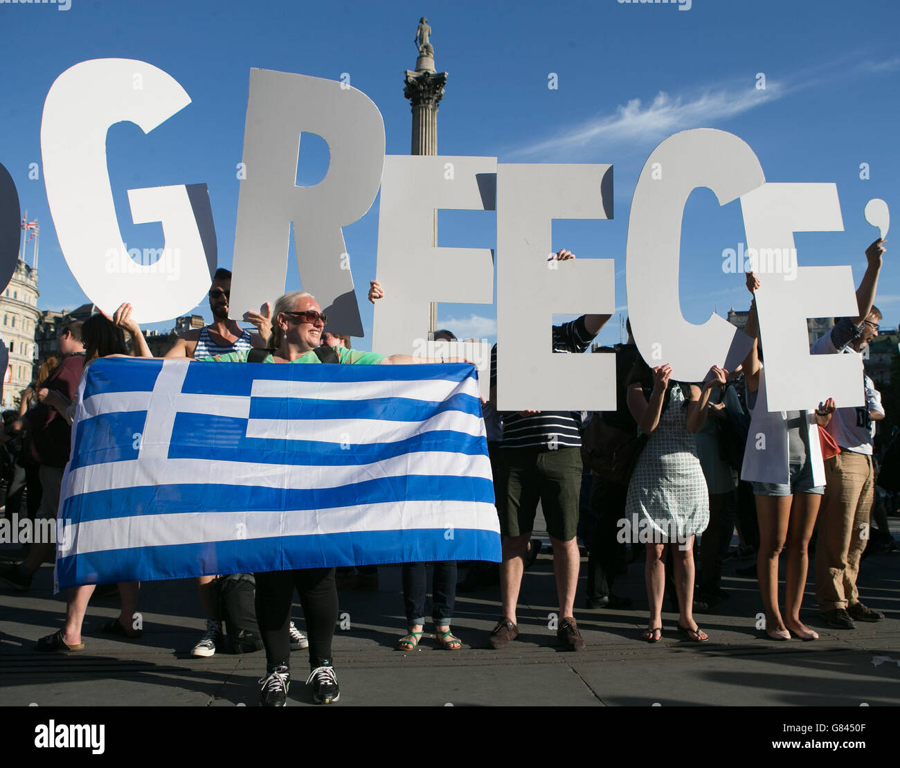 I manifestanti che hanno lettere per formare un banner prendono parte a una protesta contro la Banca centrale europea, a Trafalgar Square, Londra, per i rimborsi del debito greco. Foto Stock