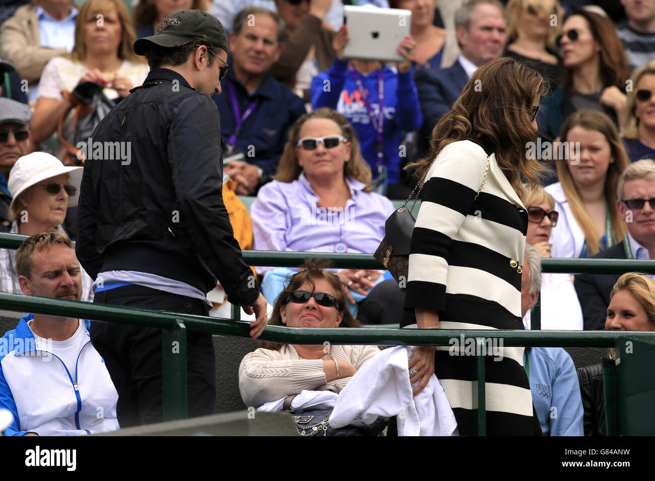 Bradley Cooper e Mirka Federer tornano al box giocatori per la partita tra Gilles Simon e Roger Federer sul campo uno durante il giorno nove dei Wimbledon Championships all'All England Lawn Tennis and Croquet Club, Wimbledon. Foto Stock