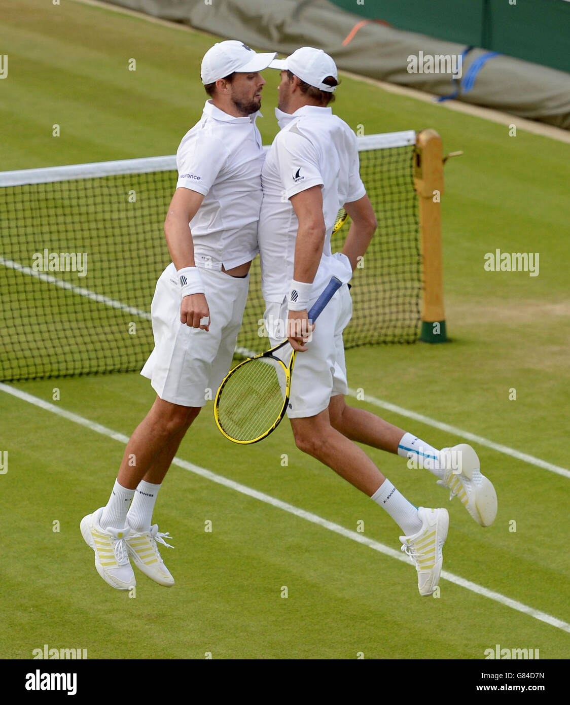 Bob e Mike Bryan festeggiano il picchiettio di Steve Johnson e Sam Querrey in doppio con un colpo di petto saltante il quinto giorno del Wimbledon Championships presso l'All England Lawn Tennis and Croquet Club di Wimbledon. Foto Stock