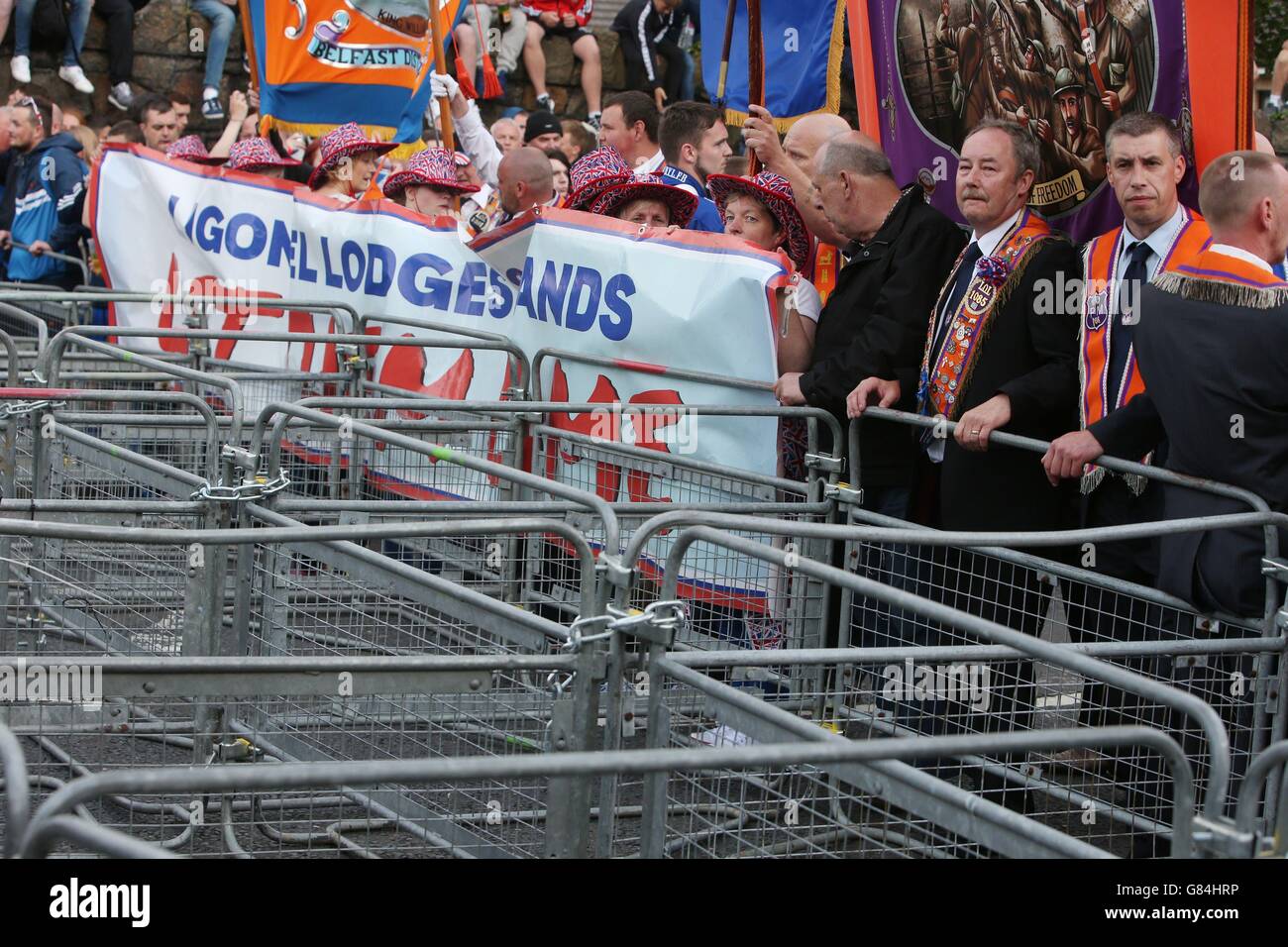 Membri dell'Ordine Arancio da barricate prima di una sfilata su Woodvale Road, a nord di Belfast, come parte delle celebrazioni annuali del dodicesimo luglio, che segnano la vittoria di Re Guglielmo III su Giacomo II nella Battaglia del Boyne nel 1690. Foto Stock