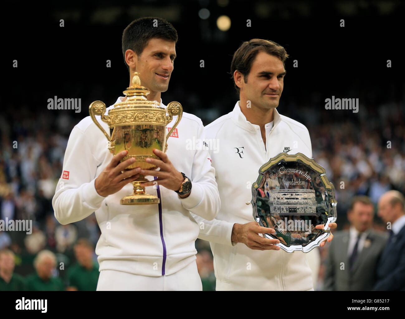 Novak Djokovic e Roger Federer posano per i fotografi con i rispettivi trofei durante il giorno tredici del Wimbledon Championships all'All England Lawn Tennis and Croquet Club, Wimbledon. Foto Stock