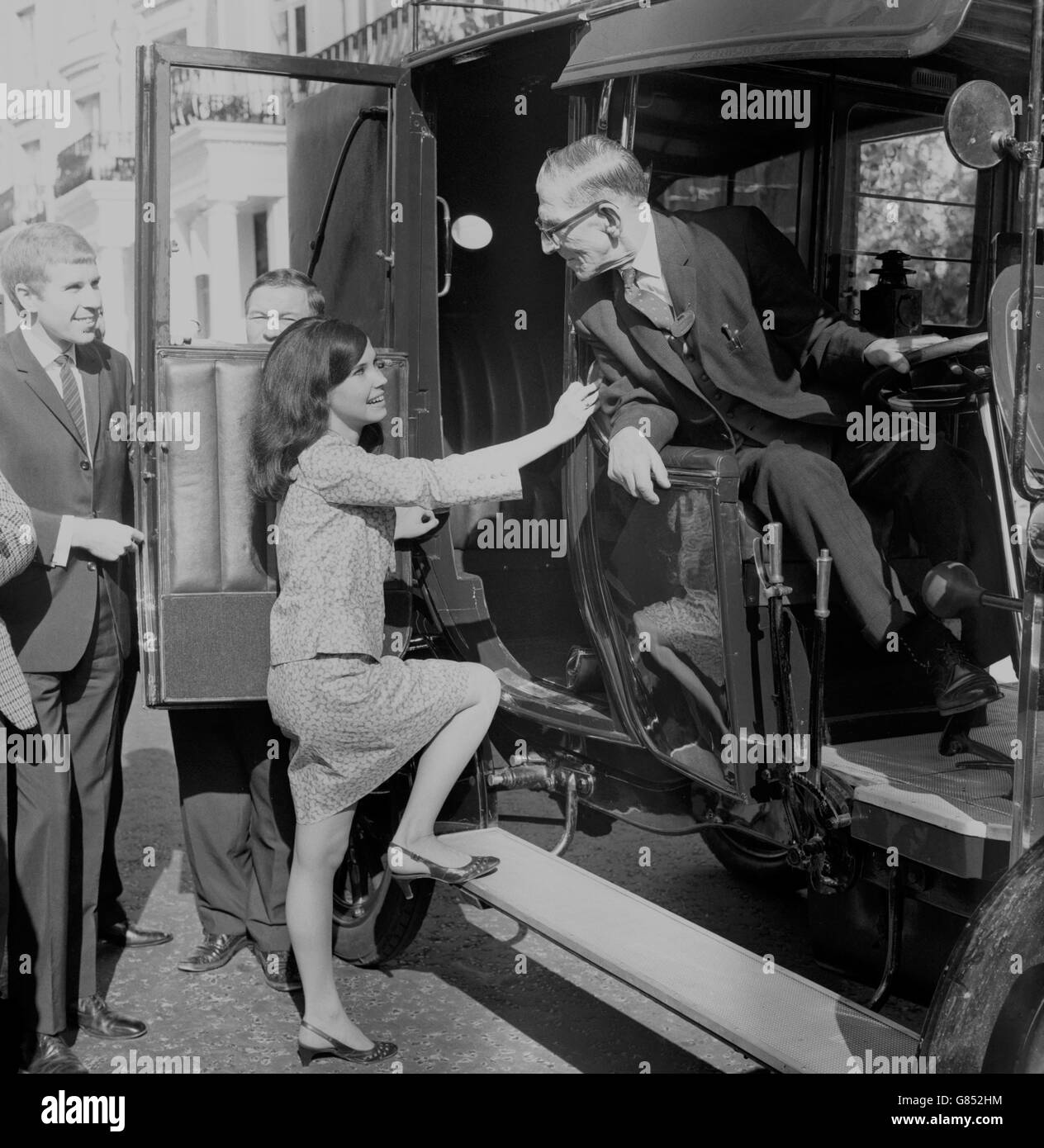 Sheila McDonnell, 21 anni, di Benfleet, Essex, salta a bordo di un taxi Unic 1907 fuori dal Royal Lancaster Hotel, Londra. Nel sedile del conducente del taxi è un altro veterano - George Todd, 75, che è il più vecchio cabbie londinese ancora sulla strada. Era uno dei 300 tassisti di Londra che hanno pranzato al nuovo Royal Lancaster come ospiti della direzione - in modo da otterrebbero un assaggio di che cosa i passeggeri che cadono all'entrata dell'hotel ottengono per i loro soldi. Foto Stock