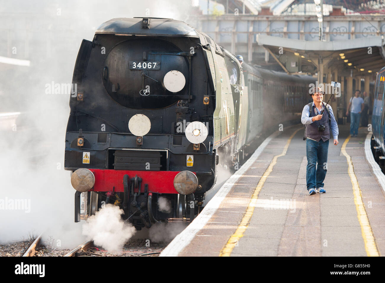 L'entusiasta di vapore David Crosby, di Brisbane, Australia, utilizza un bastone selfie per scattare una foto con la locomotiva a vapore 'Tangmere', una battaglia del 1947 della classe britannica Pacific 4-6-2, che traina il treno Dorset Coast Express per Weymouth alla stazione Victoria di Londra. Foto Stock