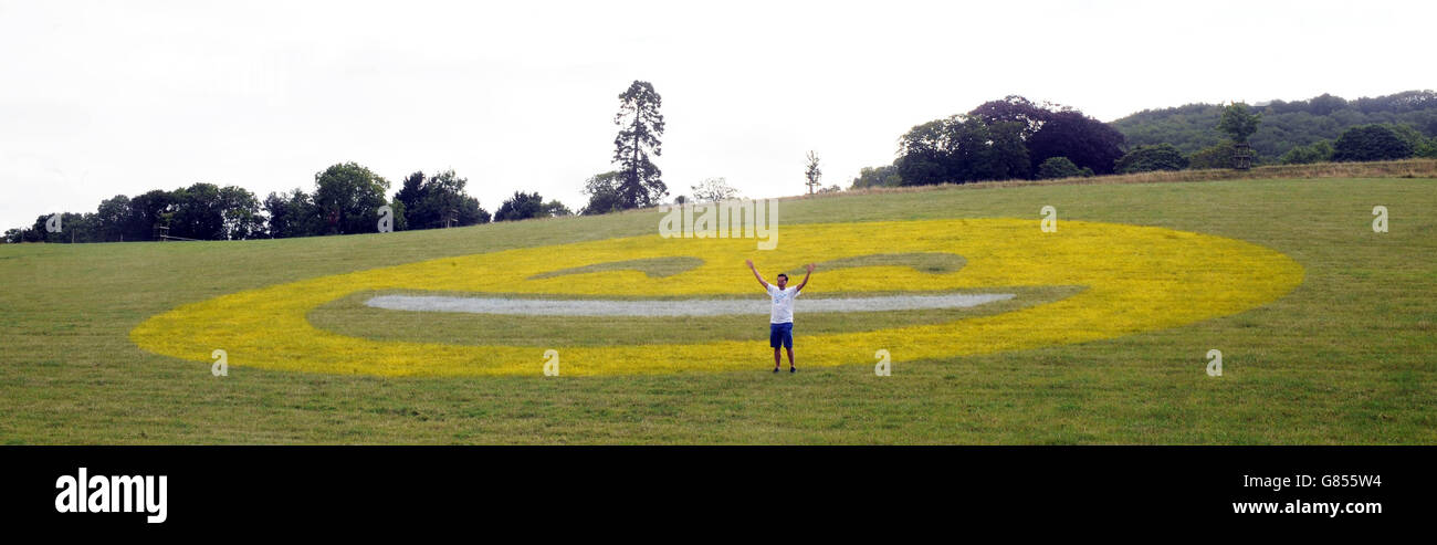 Un dipinto di 100 piedi di un'icona emoji sorridente è stato creato da Tesco Mobile in un campo vicino a Bath per sorprendere i pendolari con le più grandi emoji del mondo. Foto Stock