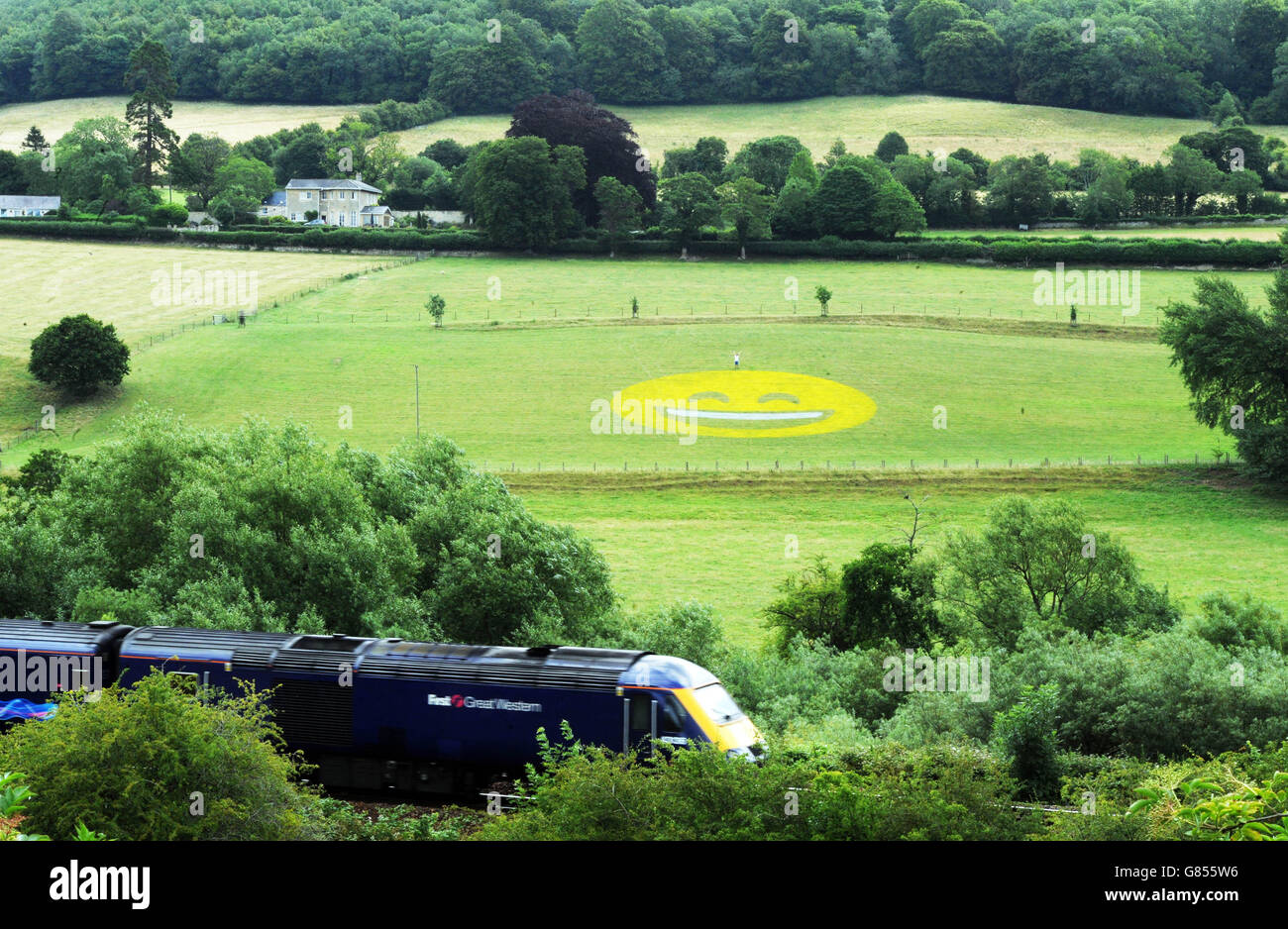 USO EDITORIALE SOLO Un dipinto di 100 piedi di un'icona emoji sorridente è stato creato da Tesco Mobile in un campo vicino a Bath per sorprendere i pendolari con le emoji più grandi del mondo. Foto Stock