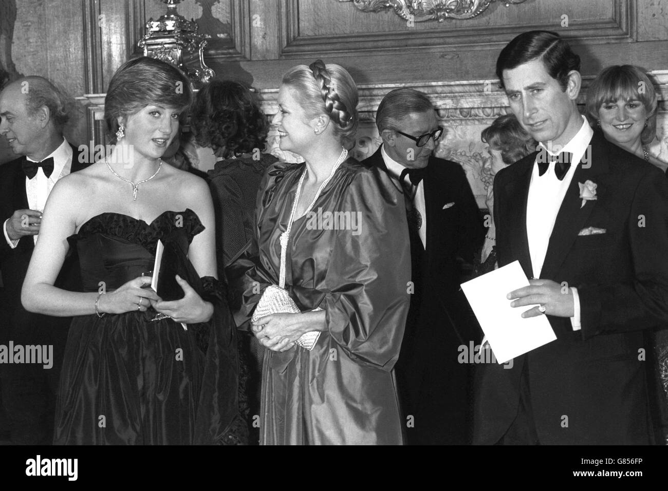 (l-r) Lady Diana Spencer, vestita con abito da sera nero in taffeta, Principessa Grace di Monaco e Principe Carlo alla Sala dei Goldsmiti di Londra. Erano tutti ospiti di una serata di intrattenimento in aiuto del Royal Opera House Development Appeal. Questo fu il primo impegno reale di Lady Diana. Foto Stock